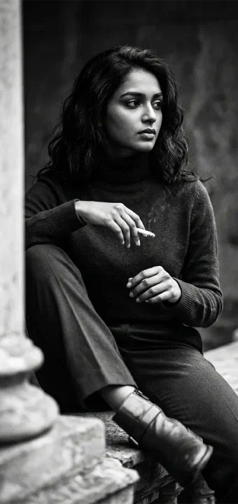 Artistic monochrome portrait of a woman resting against stone pillars